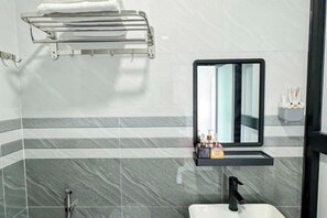 A bathroom with a mirror, sink, towel rack, and toiletries. - Sea View Hotel Phan Thiet (Phan Thiet)