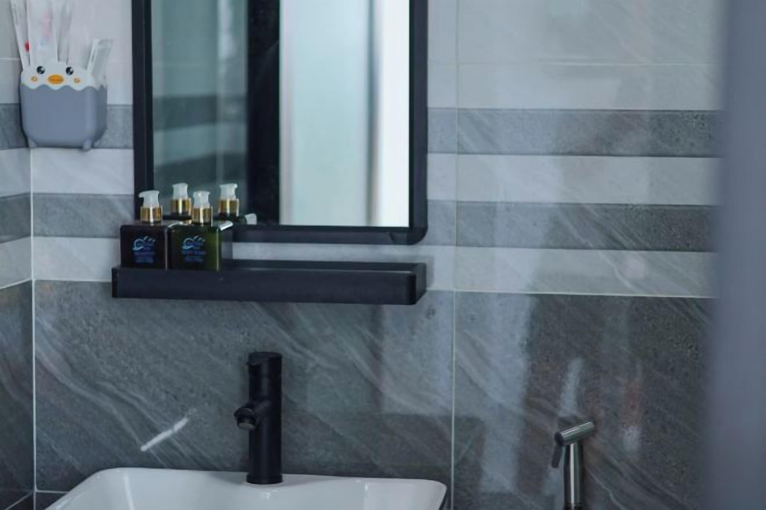 A bathroom with a white sink, black faucet, and a mirror above.
