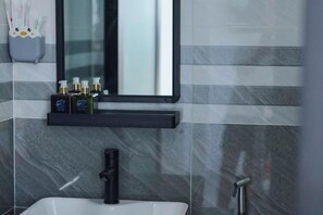 A bathroom with a white sink, black faucet, and a mirror above. - Sea View Hotel Phan Thiet (Phan Thiet)