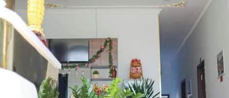 Un couloir avec, au fond, un coin cuisine comprenant des placards, un réfrigérateur et une guirlande décorative.