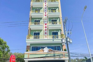 A multi-story hotel with balconies, a sign reading 'SEA VIEW HOTEL,' and a clear blue sky in the background. - Sea View Hotel Phan Thiet (Phan Thiet)