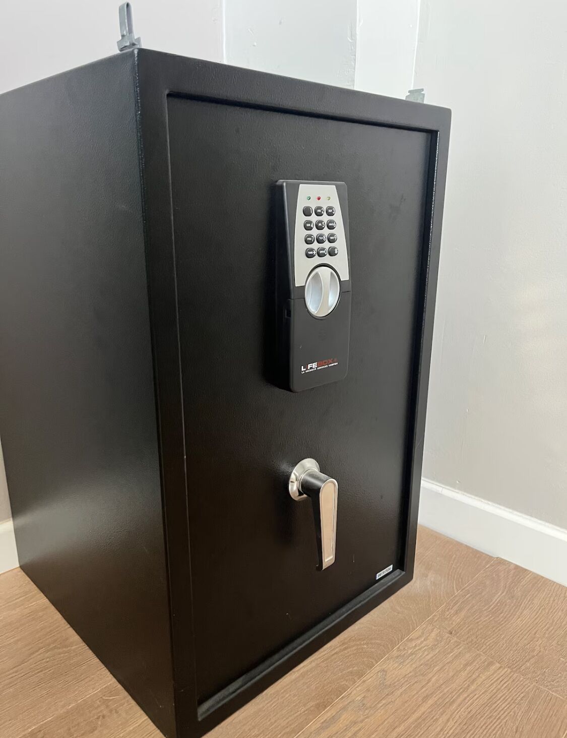 Een zwarte kluis met een keypad en een cijferslot.