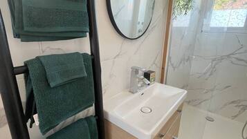 Een haardroger, handdoeken, zeep, toiletpapier