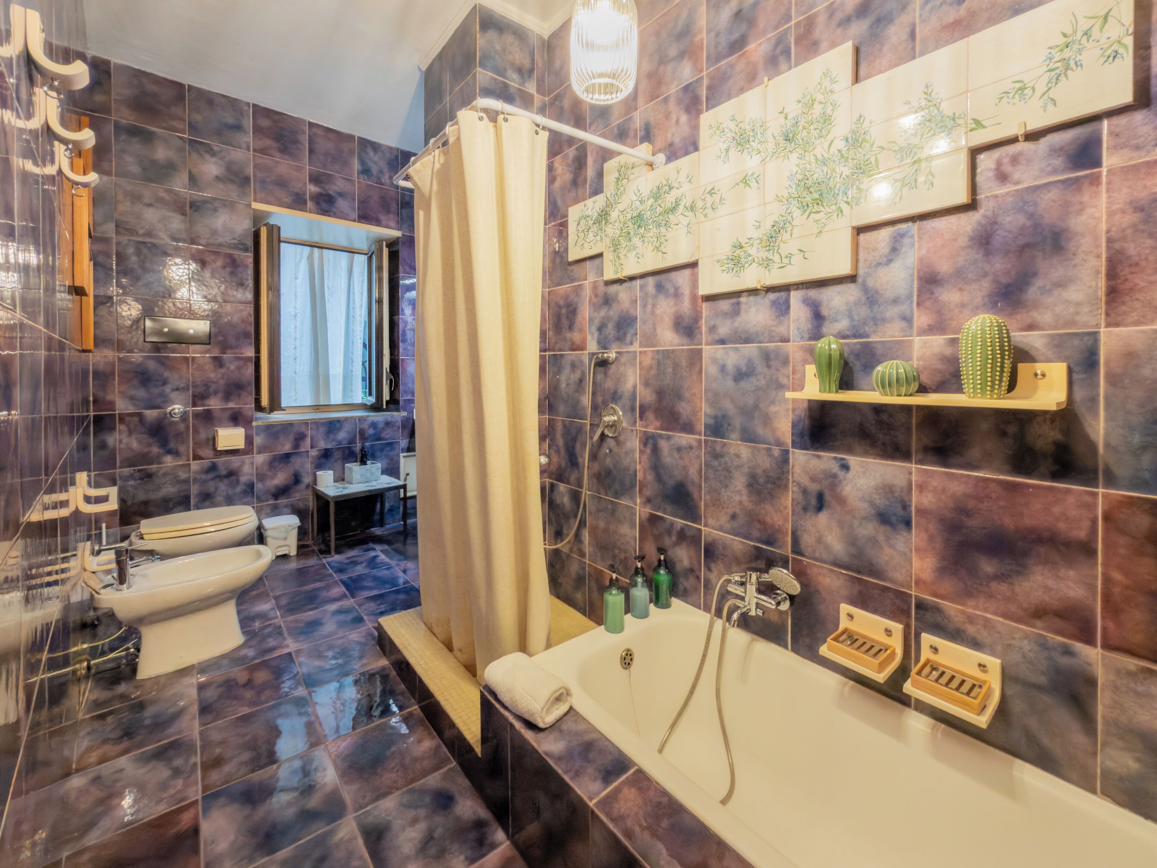 A modern bathroom with a bathtub, shower, toilet, and sink.
