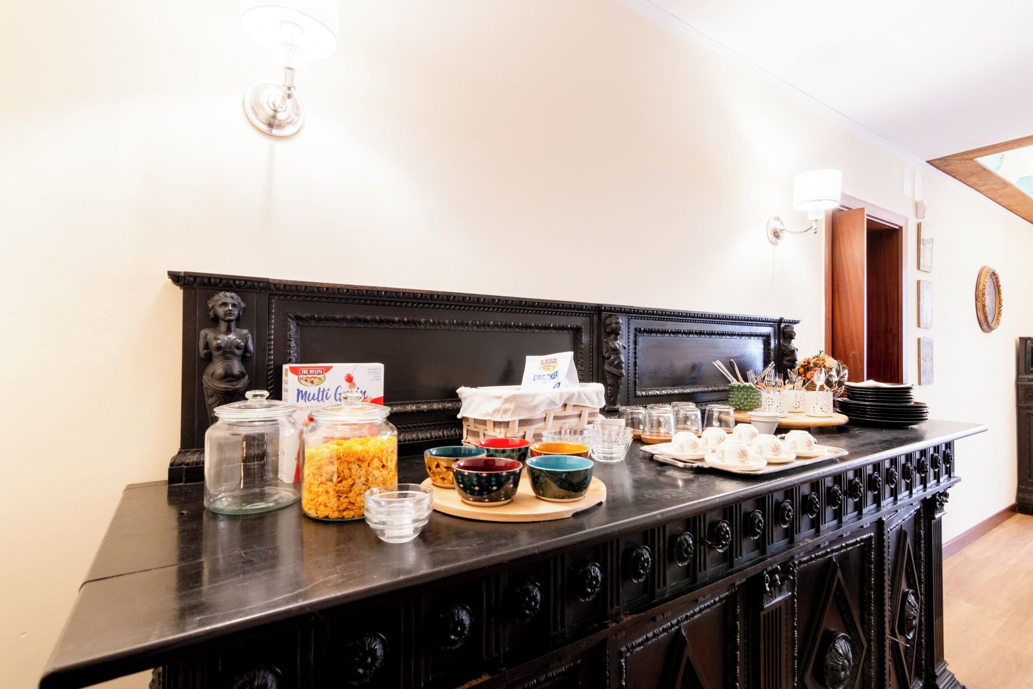 A breakfast buffet with various food items and condiments on a wooden table.