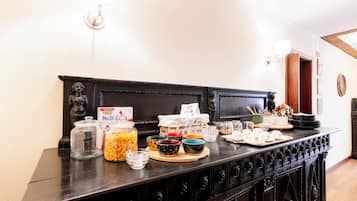 A breakfast buffet with various food items and condiments on a wooden table.