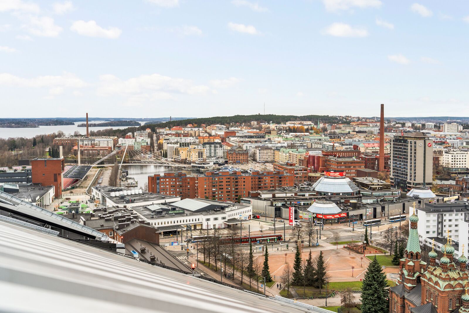 A cityscape with a prominent church, a bridge, and various buildings including a factory and a hotel.