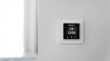 A Swigon thermostat displaying a temperature of 23°C and the time 13:19.