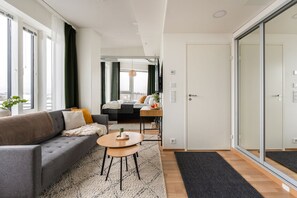 Apartamento Deluxe, 1 cama de matrimonio con sofá cama, cocina, vistas a la ciudad | Zona de estar | Televisión de pantalla plana de 55 pulgadas con canales por cable