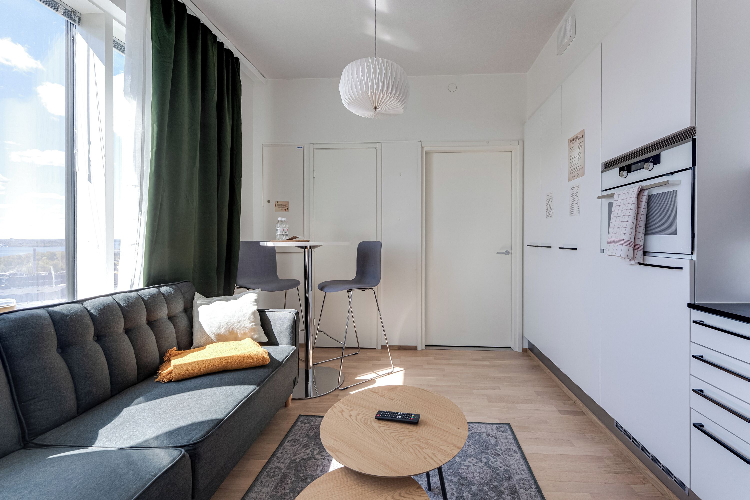 Een moderne woonkamer met een bank, een salontafel en een eethoek met stoelen.