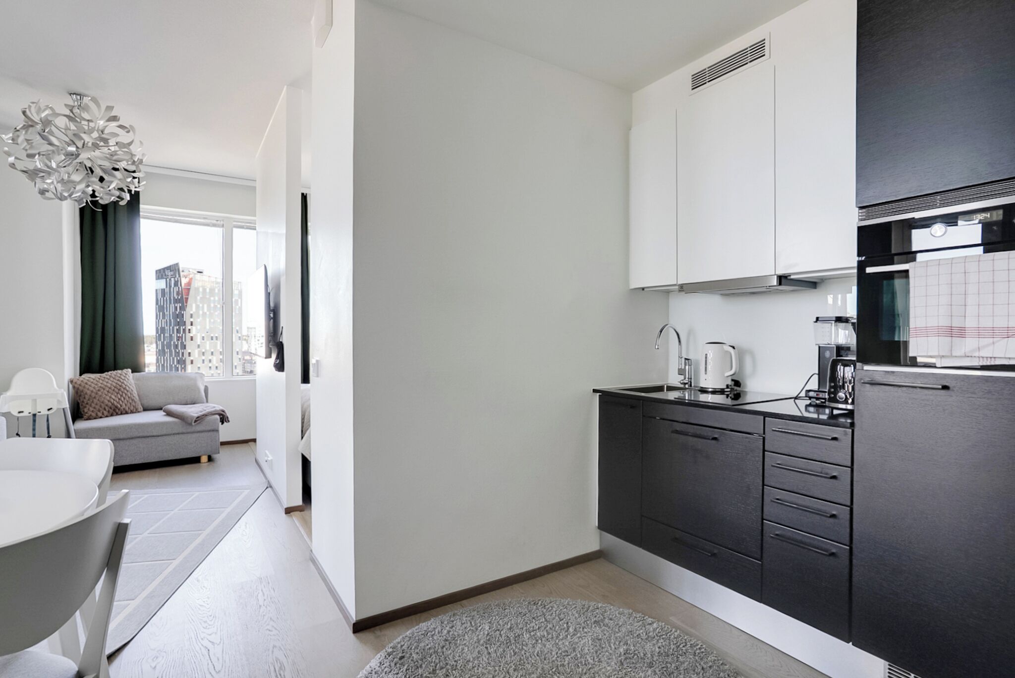 A modern kitchen with dark cabinets, a white countertop, and a built-in oven.