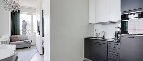 A modern kitchen with dark cabinets, a white countertop, and a built-in oven.