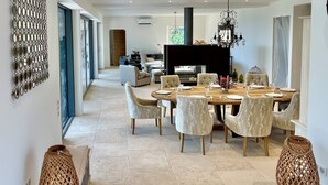 A spacious dining area with a large table set for six, surrounded by upholstered chairs. - Mas La Rose Sauvage – Elegant Stone Villa with Panoramic Views near Gordes (Murs)