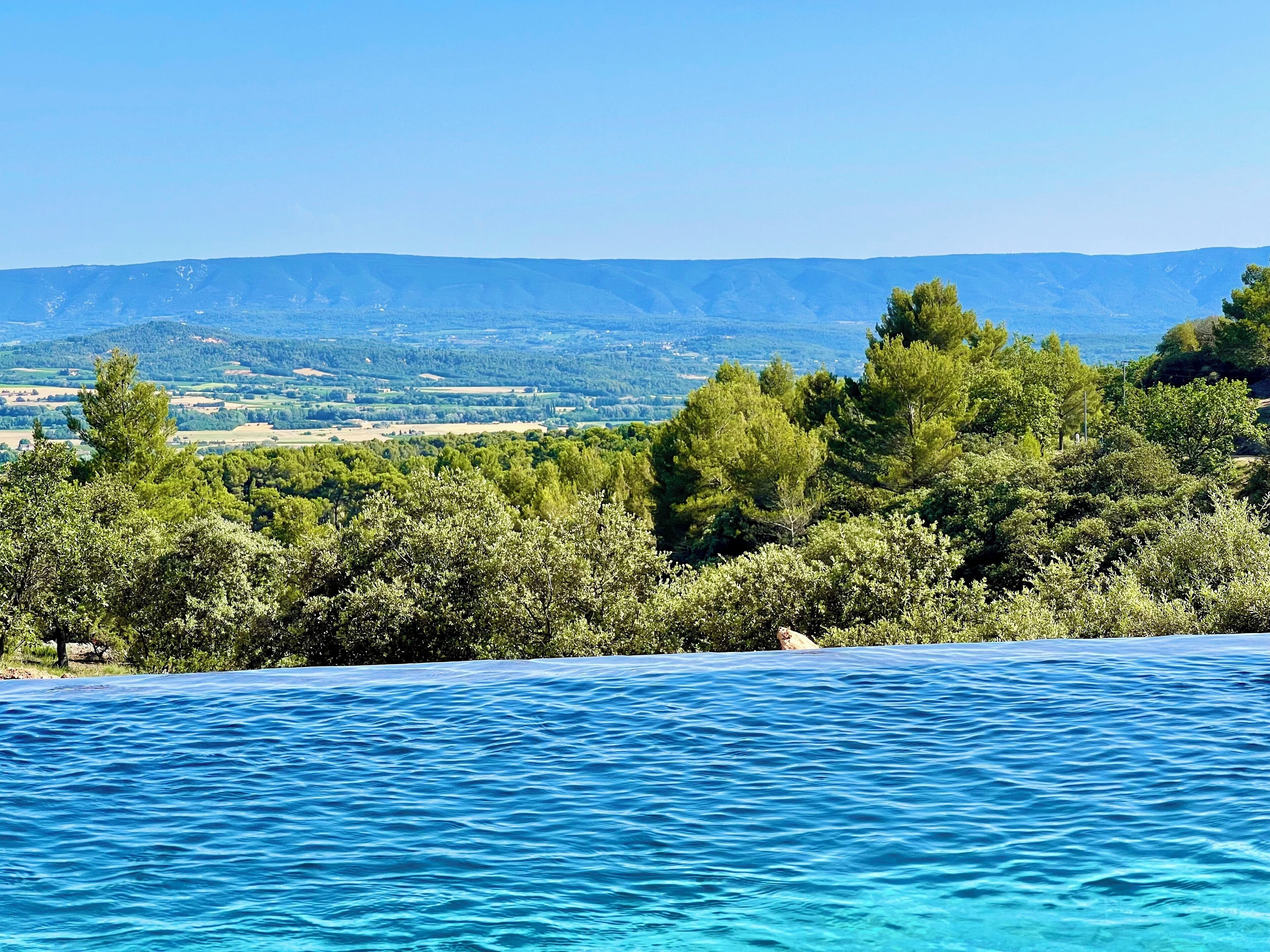 Klarer Blick auf ein Schwimmbecken mit einer Berglandschaft im Hintergrund.