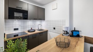 A modern kitchen with a microwave, stove, sink, and coffee maker. - Apartment 'Fewo Brünnstein - Zimmer 50' with Mountain View, Shared Garden & Wi-Fi (Oberaudorf)