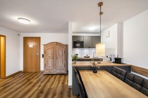 Eine moderne Küche mit Holzausstattung, einem Essbereich mit einer Bank und einem sichtbaren Kühlschrank.