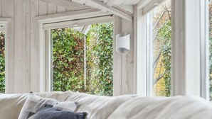 Una stanza con un letto, una finestra e vista su piante.