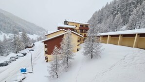 A snow-covered mountain area with a building that has multiple floors and balconies. - South-facing studio with direct runway access sleeps 4 Vallée Blanche residence (Allos)