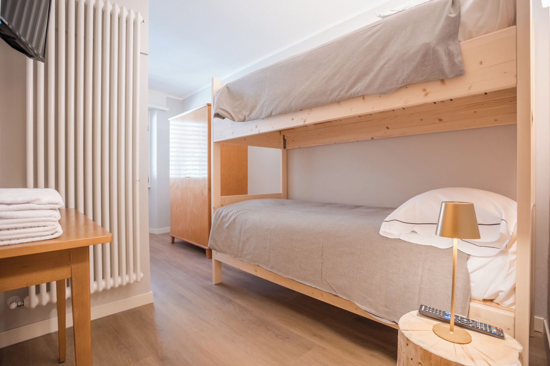 Habitación con literas, una mesa de madera y una lámpara.