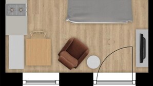 A top-down view of a hotel room with a bed, a small table, a chair, a TV, and a bathroom area with a toilet and sink. - Studio Schiederweier (Hinterstoder)
