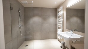 A modern bathroom with a shower, a sink, and a towel rack. - Studio Schiederweier (Hinterstoder)