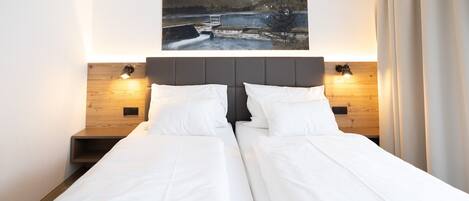 A double bed with a wooden headboard and two bedside tables with lamps.