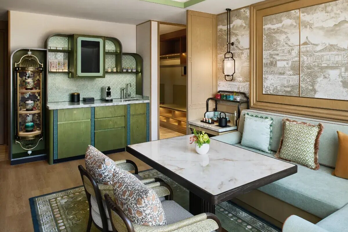 A modern living room with a marble coffee table, patterned sofa, and a decorative shelf with vases.