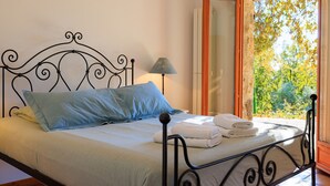 A bed with a metal frame, a blue pillow, and a white blanket. - La Bergerie – Southern charm all year round (Tourrettes-sur-Loup)