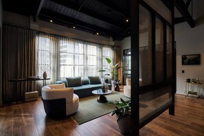A modern living room with a sofa, coffee table, and potted plants. - Heritage Penthouse Suite in the Heart of Auckland (Auckland)