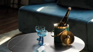 Ett modernt vardagsrum med ett runt soffbord, en flaska champagne och två glas.