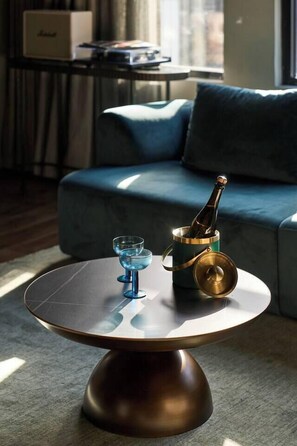 A modern living room with a round coffee table, a bottle of champagne, and two glasses. - Heritage Penthouse Suite in the Heart of Auckland (Auckland)
