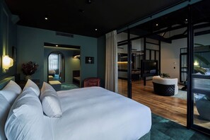 A modern hotel room with a large bed, a seating area, and a view through a glass door. - Heritage Penthouse Suite in the Heart of Auckland (Auckland)