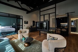 Een moderne woonkamer met een groot bed, een televisie en een eethoek.