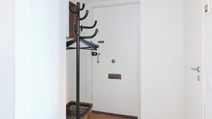 A hallway with a coat rack, a door, and a light fixture. - Beautiful Studio in Heart of Downtown (Turku)