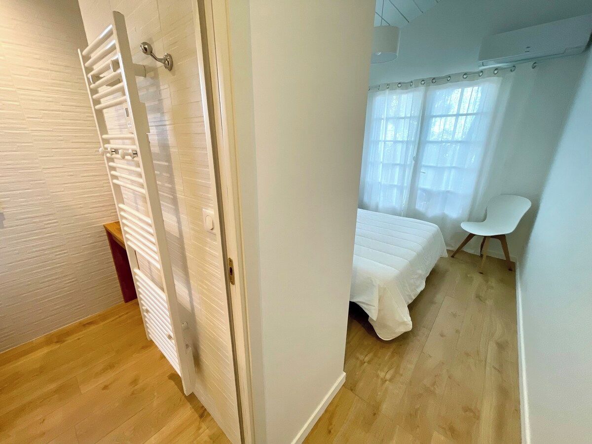 Un dormitorio con cama, una silla y un radiador.