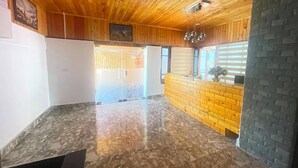 A reception area with a wooden ceiling, a marble floor, and a brick wall. - GaiaYuel (Thimphu)