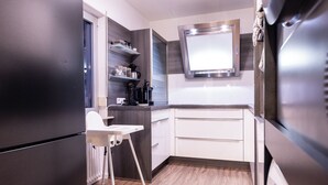 A modern kitchen with a built-in refrigerator, white cabinetry, and a microwave. - Holiday Apartment 120 m² Penthouse – Europa-Park – Strasbourg – Colmar (Lahr/Schwarzwald)