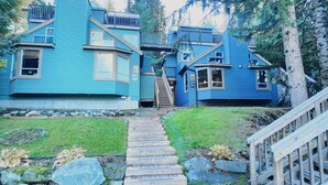 Een blauw huis met een trap naar een terras.