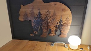 Een houten bergsilhouet met bomen aan een muur.