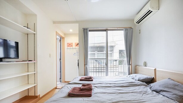 Een hotelkamer met een bed, een televisie en een balkon met uitzicht.