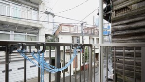 Een balkon met een metalen hekwerk en blauwe touwen.