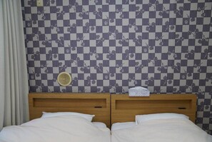A double bed with a wooden headboard, a small bedside table, and a wall-mounted fan. - Shinjuku 301 for 2 peoples, private toilet + small kitchen (Nakano City)