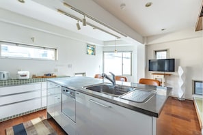 Een koelkast, een magnetron, kookgerei, borden en bestek