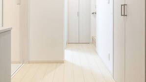 A corridor with white walls and doors, leading to a room with a tiled floor. - Near Shinjuku 3 stops (Suginami City)