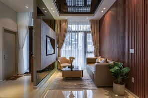 A modern living room with a glass coffee table, a sofa, and a potted plant. - Life Travel Villa - Novaworld Phan Thiet (Phan Thiet)