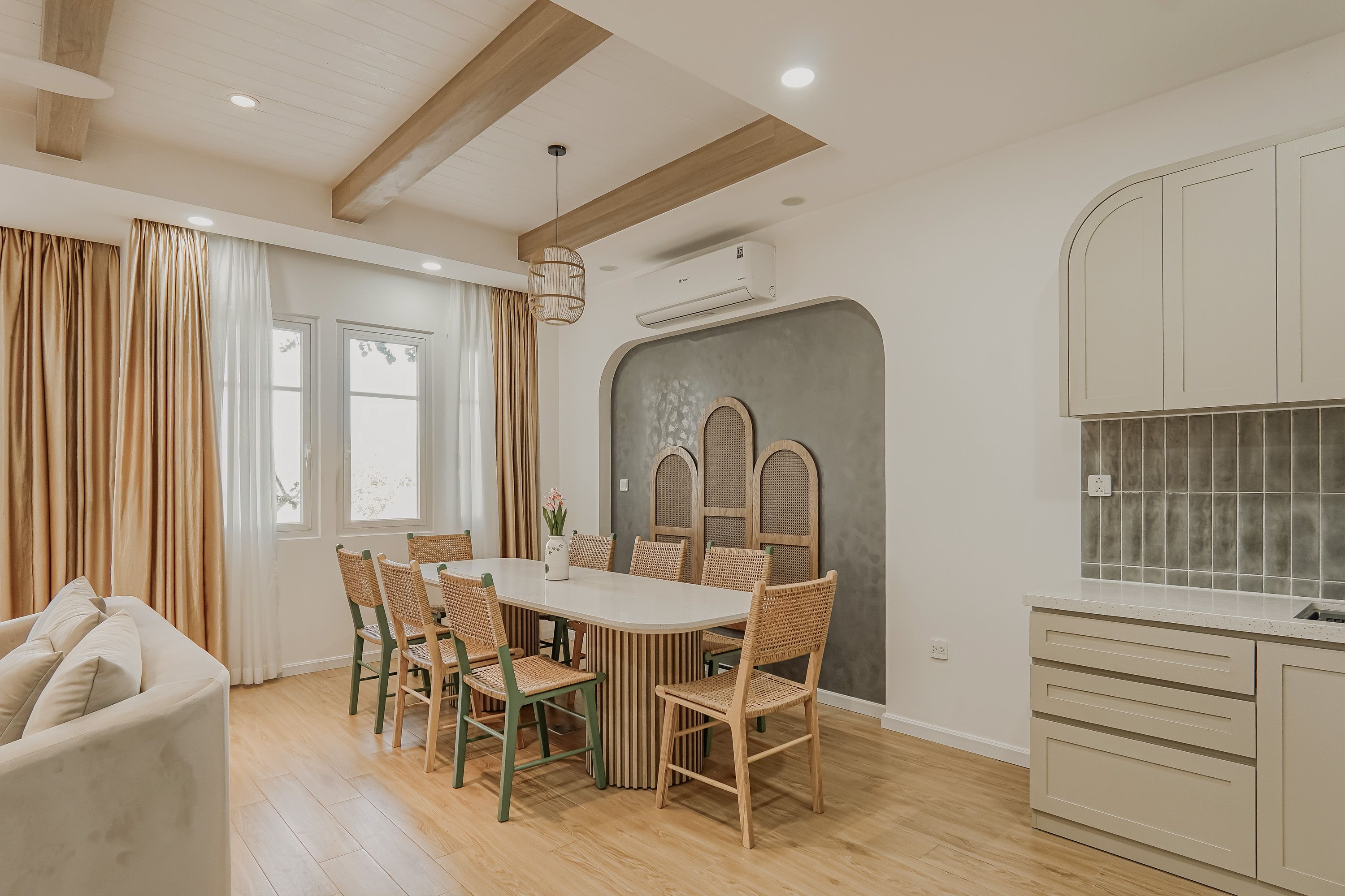 A modern kitchen with a dining area, wooden flooring, and a built-in stove.