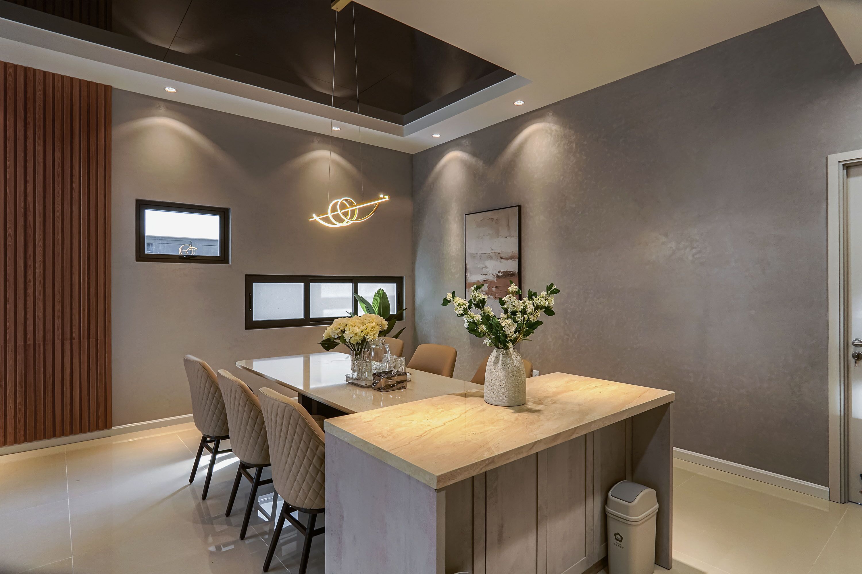 Een moderne keuken met een centraal eiland, hanglampen en uitzicht op de omgeving.