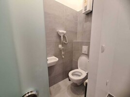Uma casa de banho moderna com sanita, lavatório e cabine de duche.