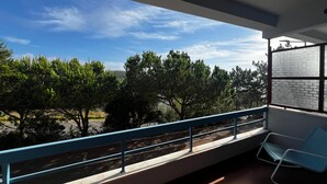 Un balcon donnant sur des arbres et un ciel dégagé.
