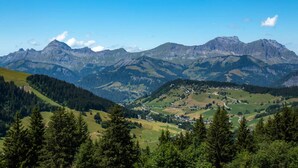 Eine gebirgige Landschaft mit einem Tal und einer kleinen Siedlung.